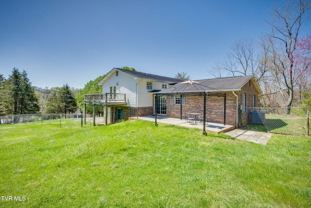 rear view of house featuring a yard, a patio area, and a fenced backyard