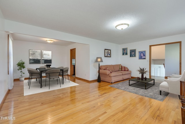 living area featuring light wood-style floors and baseboards