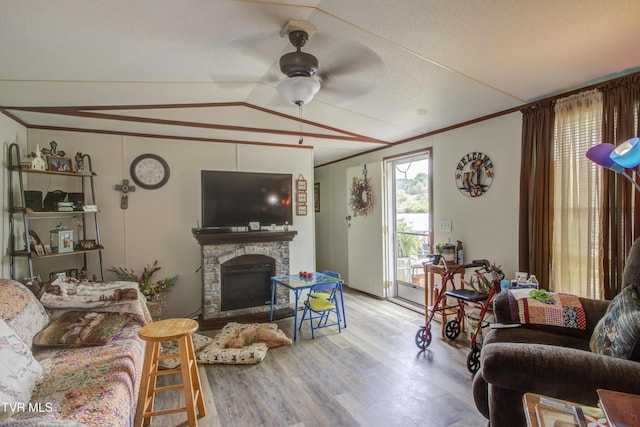 90 Darnell Rd, Greeneville, TN 37743 - living room with ornamental molding, vaulted ceiling, a ceiling fan, a stone fireplace, and wood finished floors