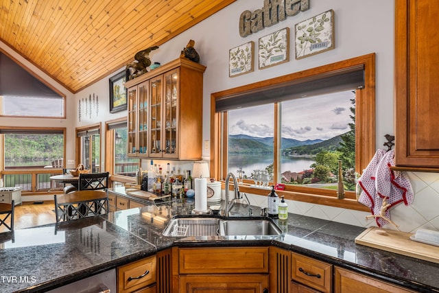 589 Harbor Point Rd, Butler, TN 37640 - kitchen with a sink, tasteful backsplash, vaulted ceiling, brown cabinets, and glass insert cabinets