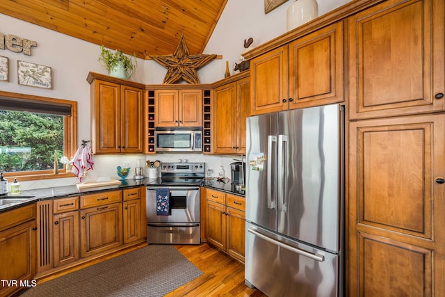 589 Harbor Point Rd, Butler, TN 37640 - kitchen featuring stainless steel appliances, open shelves, lofted ceiling, dark countertops, and brown cabinets