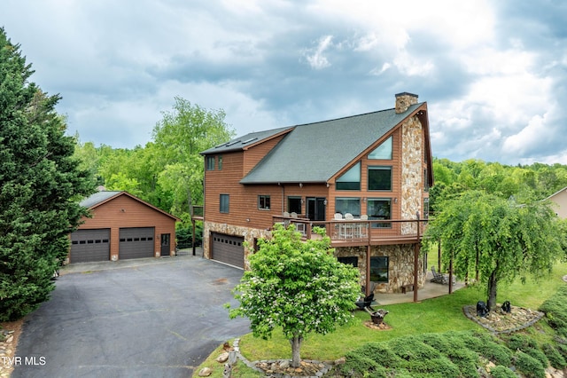 589 Harbor Point Rd, Butler, TN 37640 - rear view of house featuring stone siding, a chimney, a shingled roof, a deck, and a detached garage