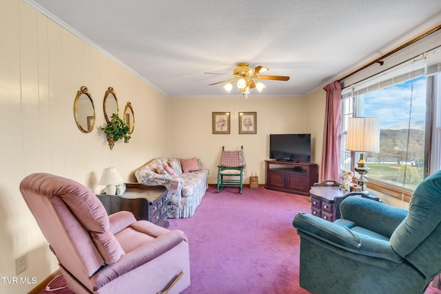 living area with a textured ceiling, carpet flooring, ceiling fan, and ornamental molding