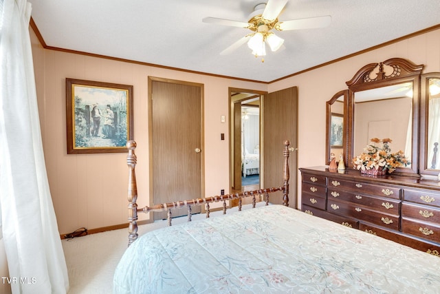 carpeted bedroom featuring baseboards, crown molding, and a ceiling fan