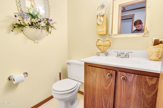 bathroom with toilet, tile patterned floors, vanity, and baseboards