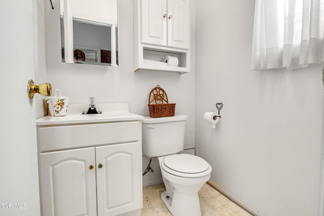 half bathroom with toilet, vanity, and baseboards