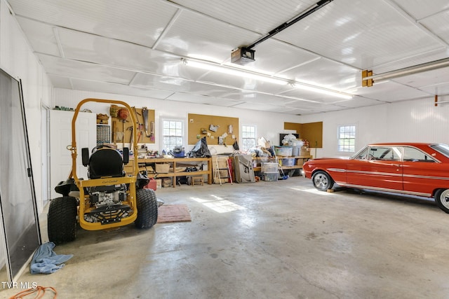 garage with a garage door opener and a workshop area