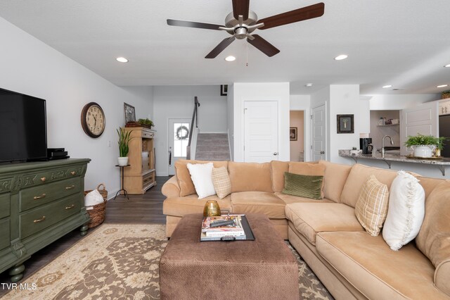 living room featuring stairway, a ceiling fan, wood finished floors, baseboards, and recessed lighting