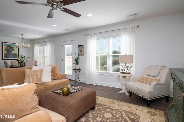 living room with baseboards, recessed lighting, visible vents, ceiling fan with notable chandelier, and wood finished floors