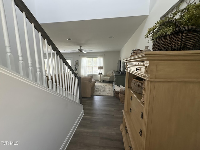 hallway featuring baseboards, stairs, and dark wood-style flooring