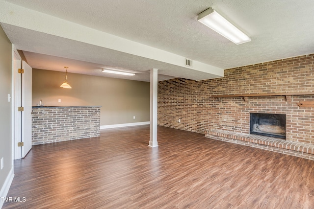 132 Lancaster Dr, Kingsport, TN 37663 - unfurnished living room with brick wall, wood finished floors, a textured ceiling, and a fireplace
