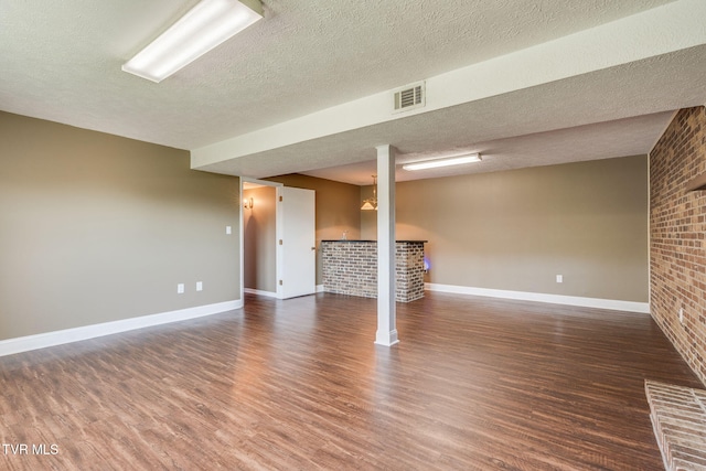 132 Lancaster Dr, Kingsport, TN 37663 - finished below grade area with wood finished floors, a textured ceiling, a fireplace, and brick wall