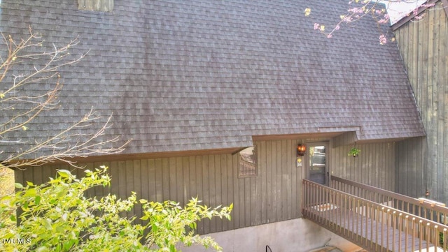 entrance to property featuring roof with shingles
