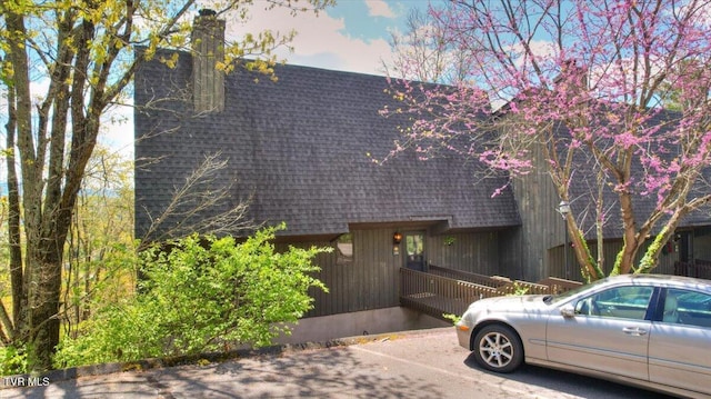view of front of property with a chimney and a shingled roof