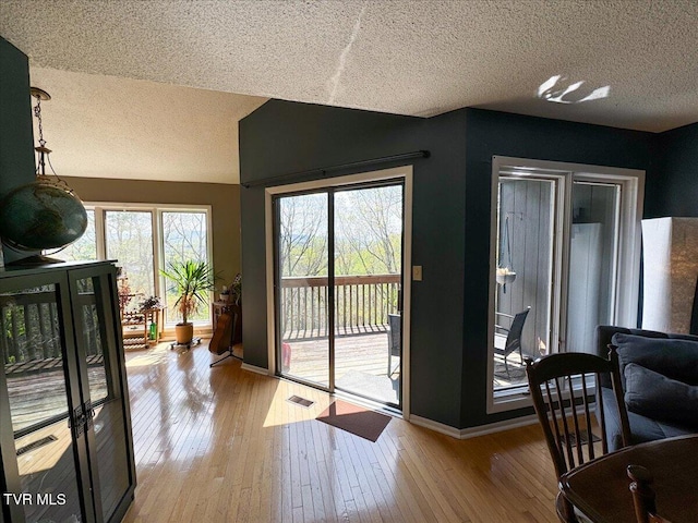 entryway with hardwood / wood-style flooring, a textured ceiling, and baseboards
