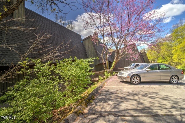 view of property exterior featuring a shingled roof and a chimney