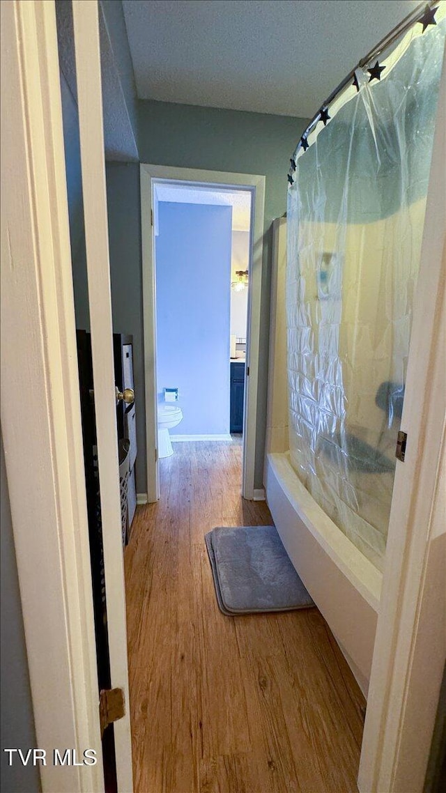 bathroom featuring toilet, baseboards, and wood finished floors