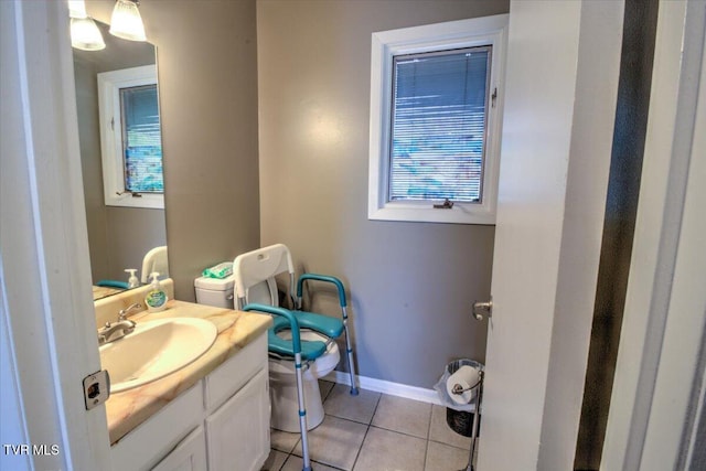 bathroom with toilet, vanity, baseboards, and tile patterned flooring