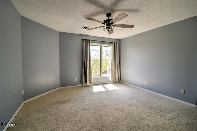 carpeted spare room with baseboards, visible vents, a textured ceiling, and a ceiling fan