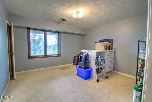interior space featuring visible vents, baseboards, carpet, and a textured ceiling
