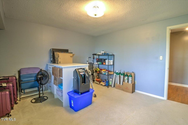 interior space featuring carpet, a textured ceiling, and baseboards