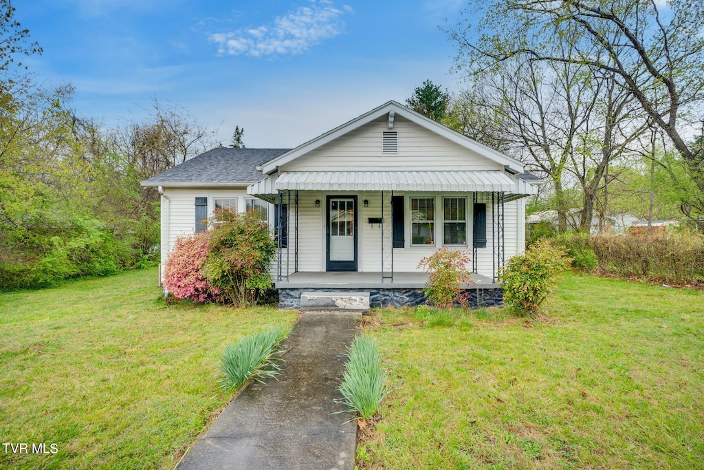 bungalow featuring covered porch and a front lawn