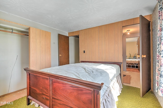 bedroom featuring wood walls and light colored carpet