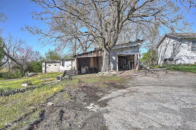 exterior space with driveway and an outdoor structure