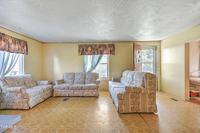 living area with visible vents and a textured ceiling