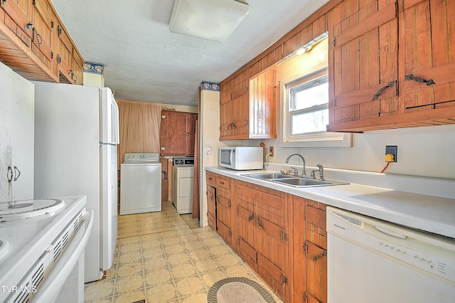 kitchen featuring a sink, light countertops, white appliances, brown cabinetry, and light floors