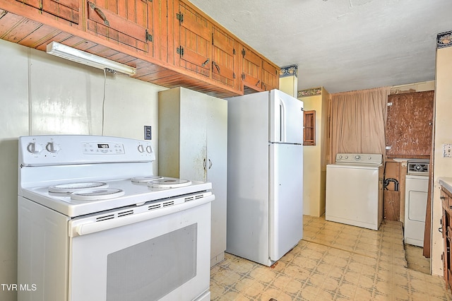 kitchen with white appliances, light floors, brown cabinetry, separate washer and dryer, and light countertops