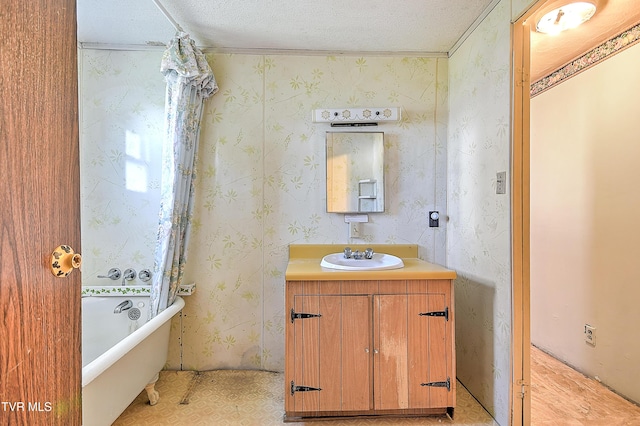 bathroom featuring vanity, a textured ceiling, and a soaking tub