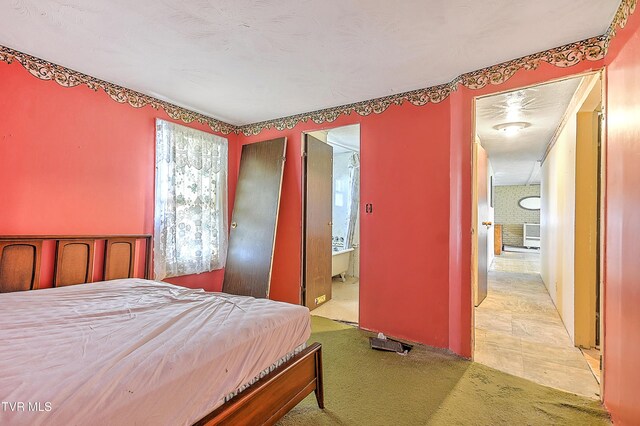 bedroom with light carpet and ensuite bathroom