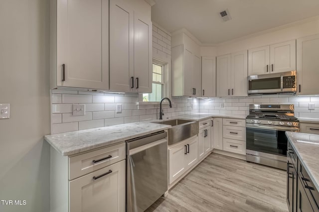 74 Slonaker Cir, Jonesborough, TN 37659 - kitchen with a sink, appliances with stainless steel finishes, visible vents, light wood-style floors, and light stone countertops
