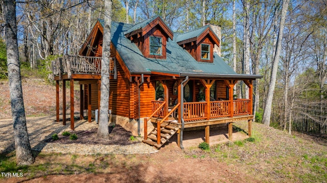 113 Tanner Dr, Elizabethton, TN 37643 - view of front facade with metal roof, log siding, covered porch, and a chimney