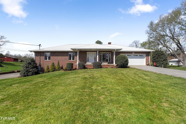 single story home with a garage, a front lawn, brick siding, a chimney, and driveway