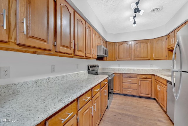 511 Hickory Rd Unit 511, Bristol, TN 37620 - kitchen featuring appliances with stainless steel finishes, light stone counters, light wood-style floors, and a textured ceiling