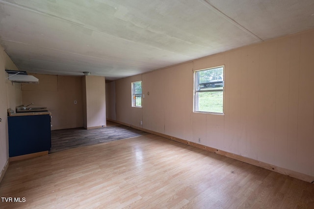 spare room with baseboards and light wood-style floors