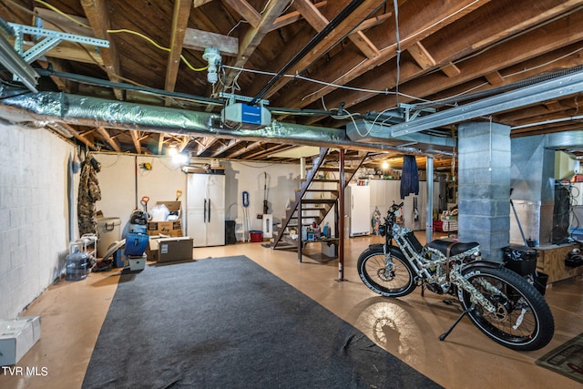 unfinished basement with freestanding refrigerator, stairway, and concrete block wall