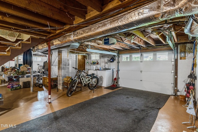 garage with a garage door opener and washing machine and dryer