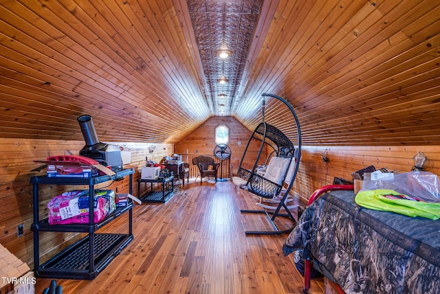 bedroom with hardwood / wood-style floors, wooden ceiling, wood walls, and lofted ceiling