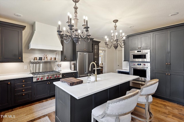 20268 Heron Cir, Abingdon, VA 24211 - kitchen with light countertops, a chandelier, stainless steel appliances, wood finished floors, and custom range hood