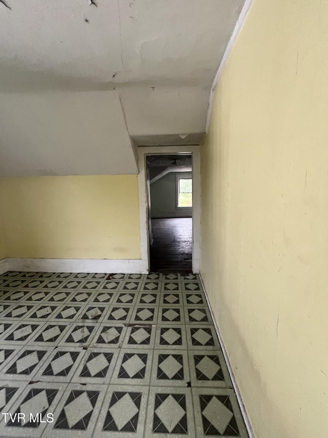 corridor featuring tile patterned floors and baseboards