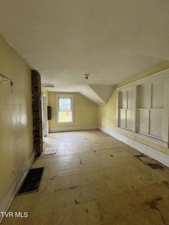 additional living space featuring visible vents, baseboards, tile patterned floors, and lofted ceiling