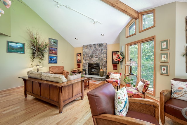 living area with track lighting, high vaulted ceiling, light wood finished floors, and beam ceiling
