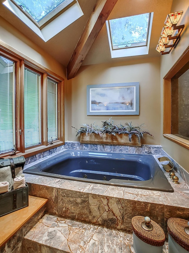 bathroom featuring beam ceiling, a skylight, and a tub with jets