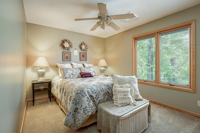 carpeted bedroom with ceiling fan and baseboards