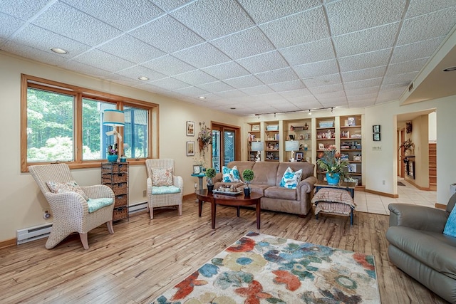 living room with built in features, baseboards, and wood finished floors