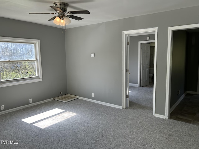 carpeted spare room with baseboards and a ceiling fan