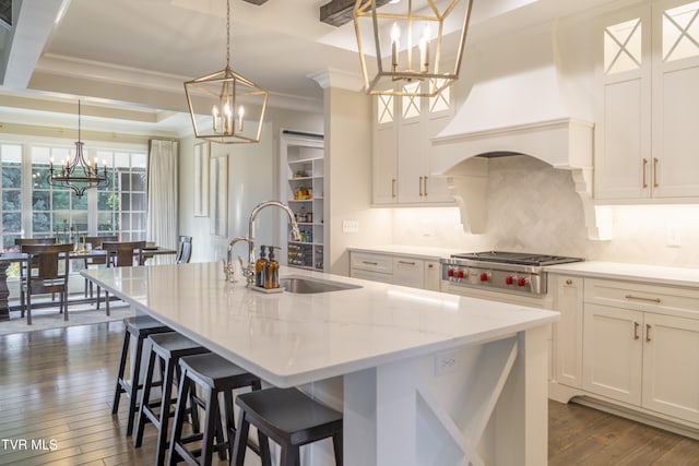 kitchen featuring custom range hood, ornamental molding, a chandelier, backsplash, and a sink
